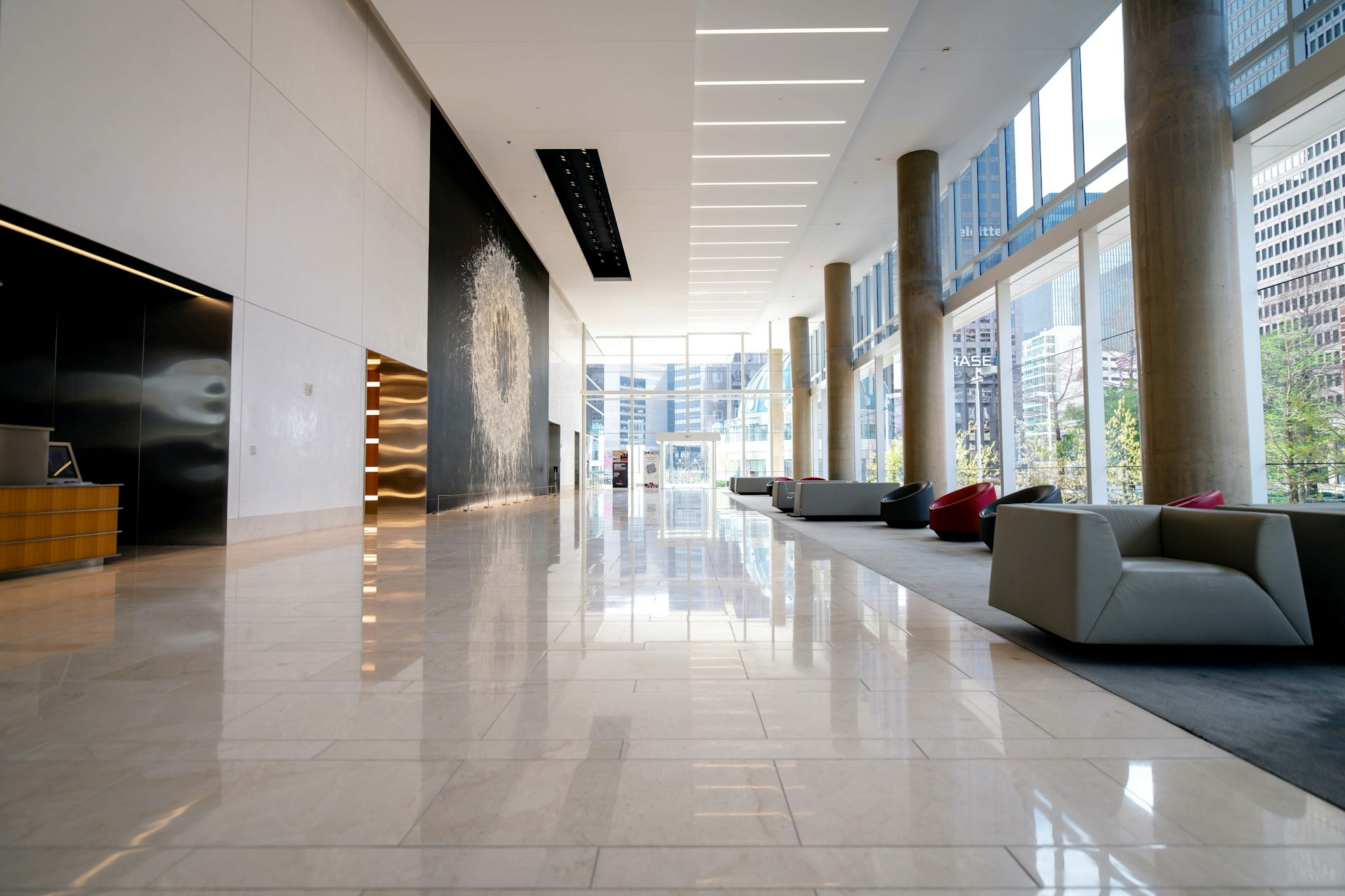 Bright and spacious modern hotel lobby featuring polished marble floors, contemporary seating, floor-to-ceiling windows, and elegant architectural details—ideal inspiration for luxury hospitality projects.